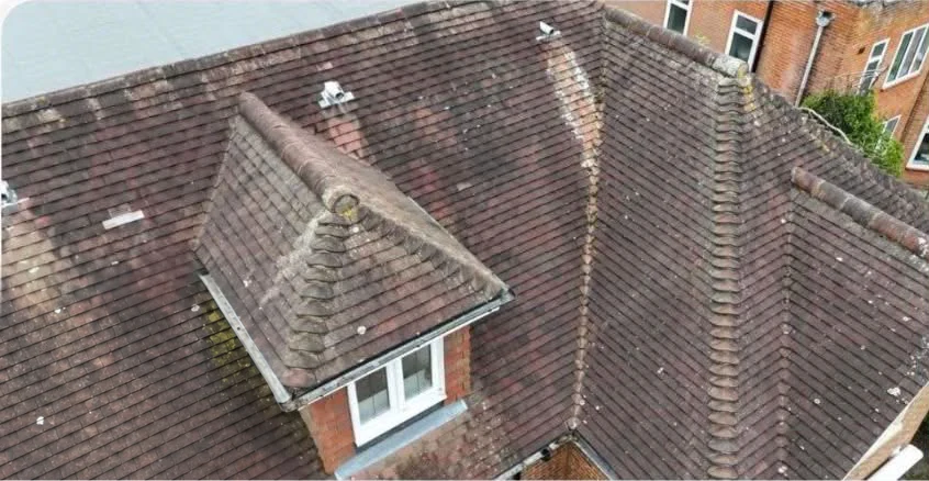 Weathered pitched roof with a dormer before replacement