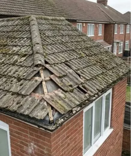 Weathered roof tiles with damaged ridge before repair