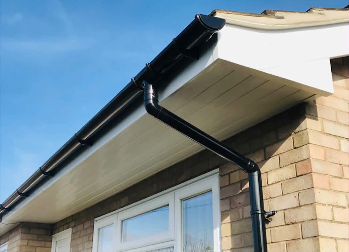 New black guttering, fascias and soffits against a blue sky
